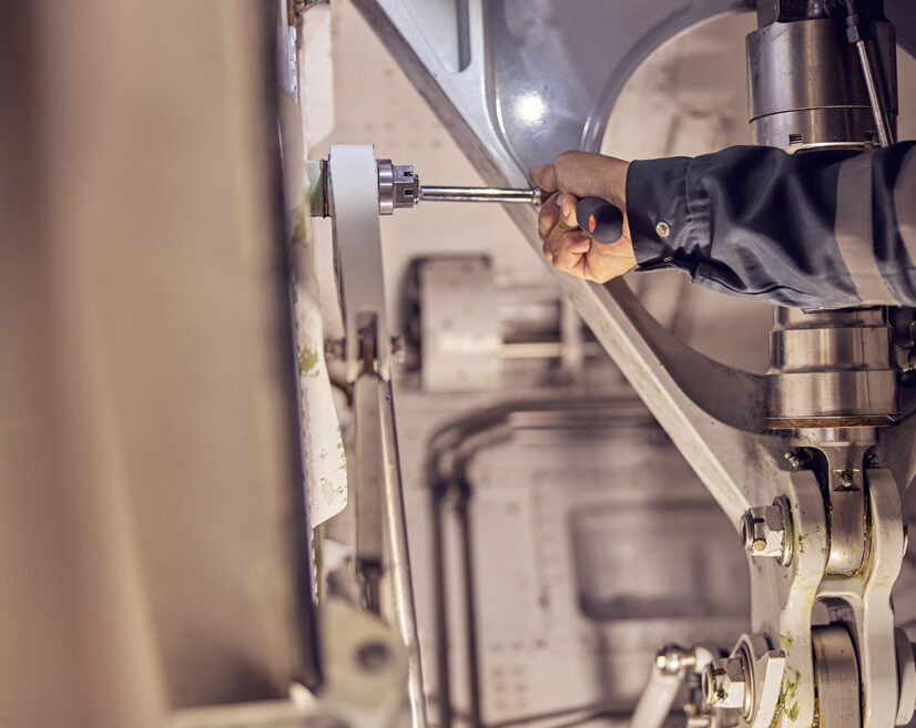 Cropped head portrait of mechanic hand using special tools for fixing and checking system of passenger aircraft in the aviation hangar